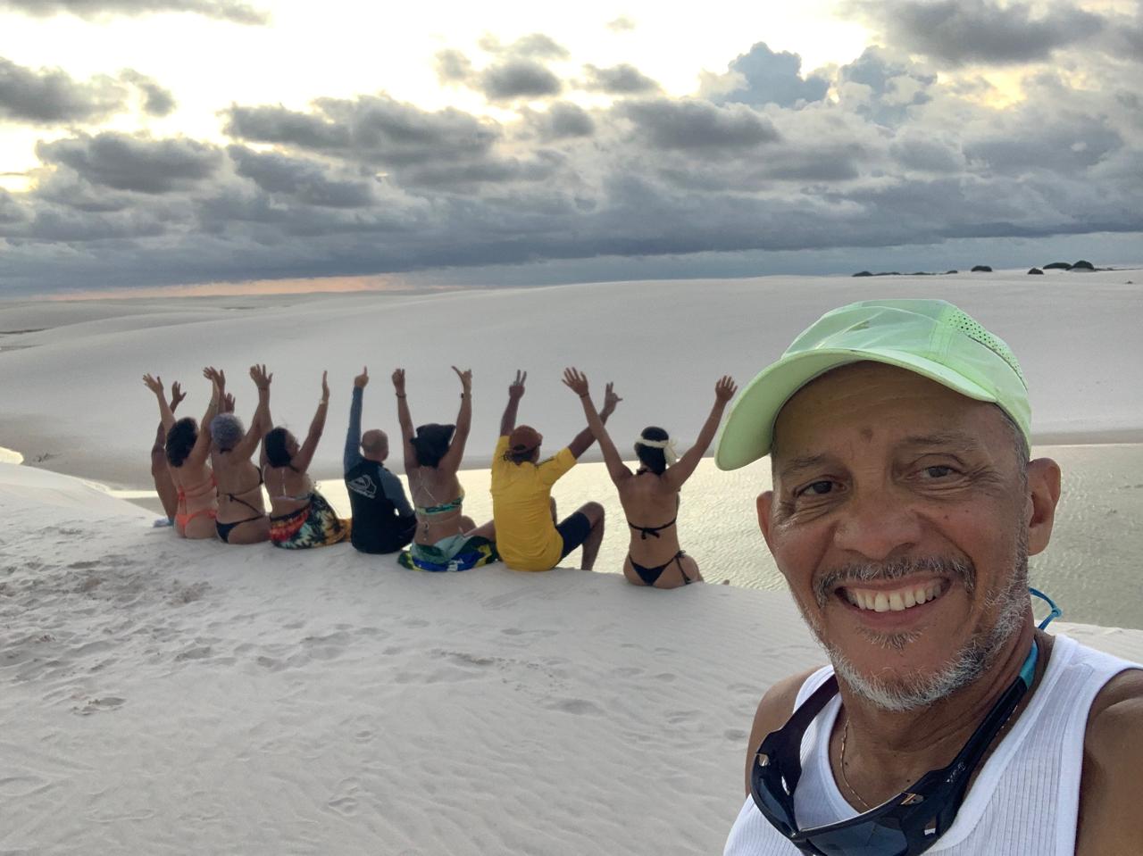 Pedro com grupo nas dunas ao pôr do sol