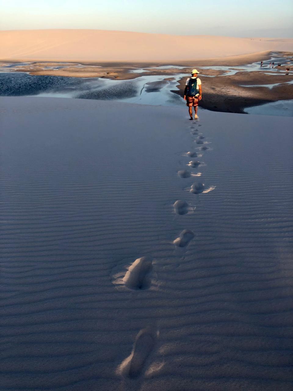 Pegadas na duna ao entardecer