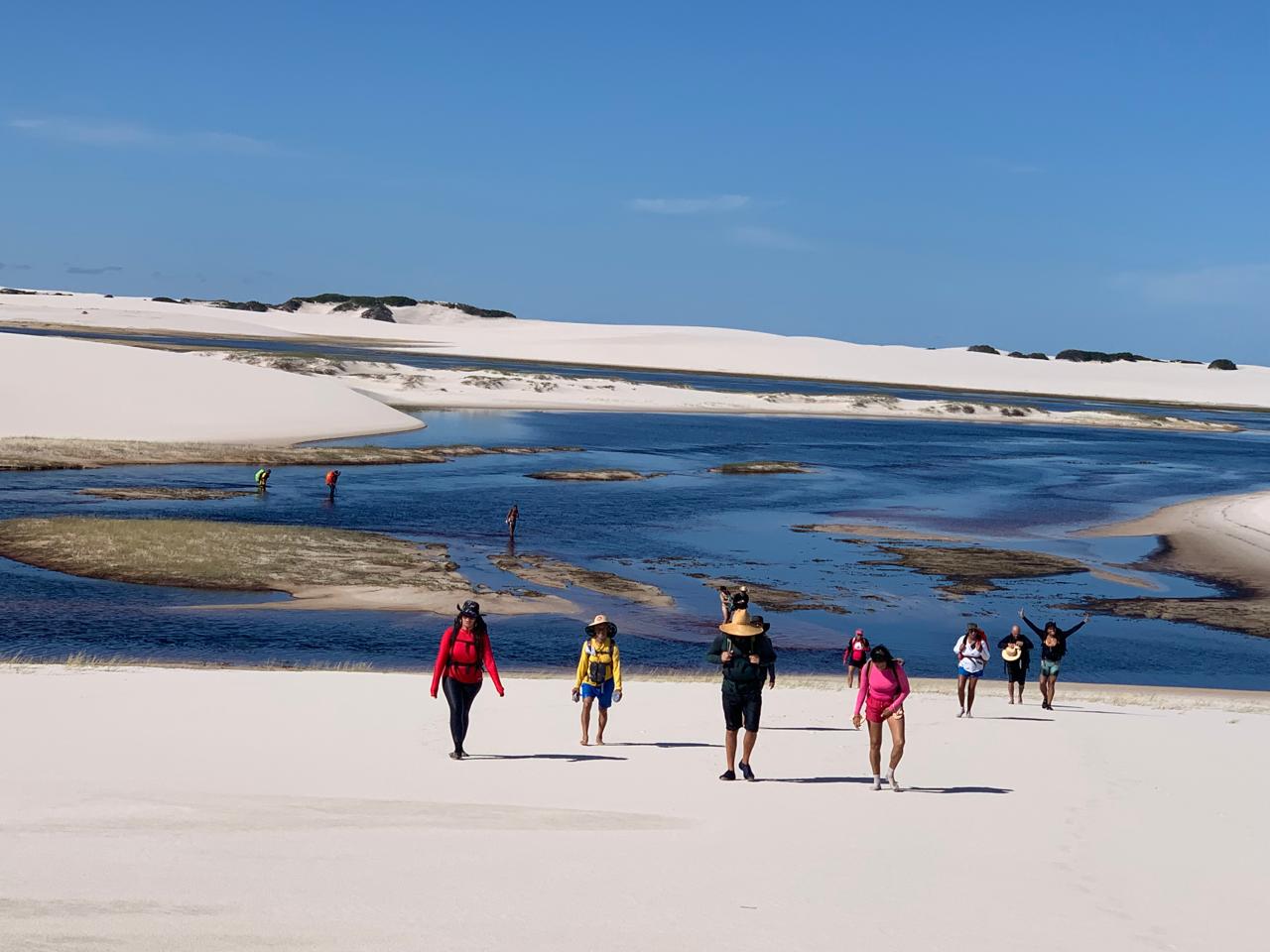 Grupo atravessando banco de areia entre lagoas